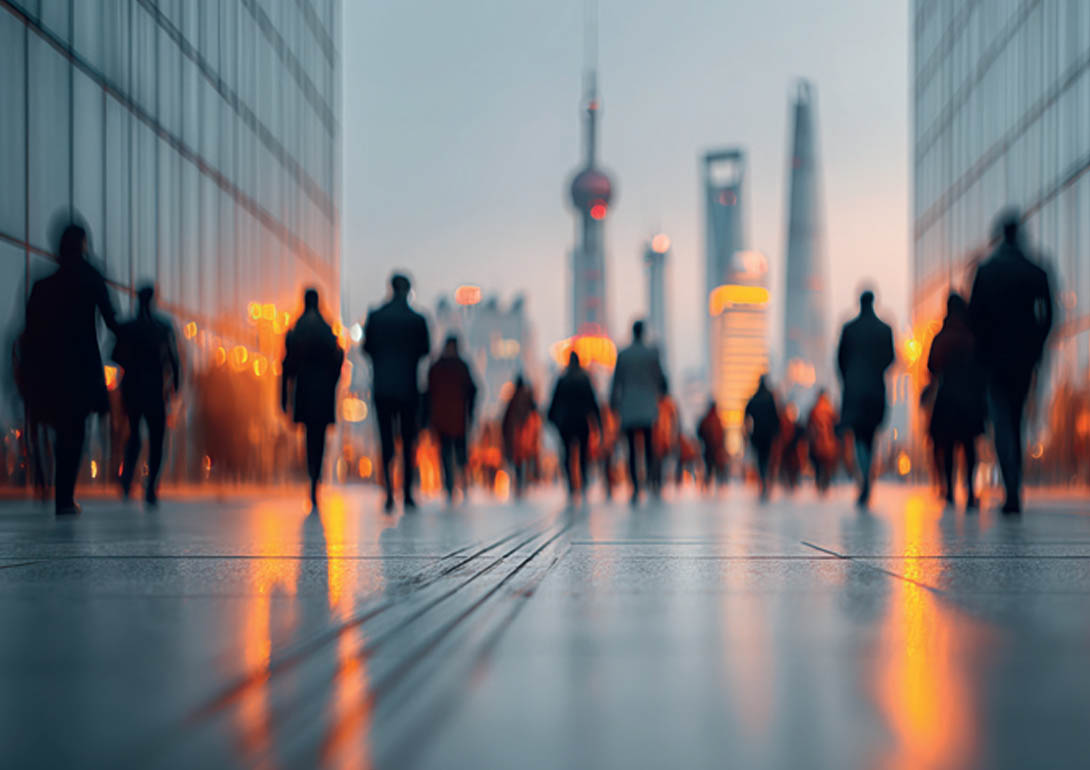 Viele Menschen laufen eine Straße entlang, am Ende sieht man eine Skyline.