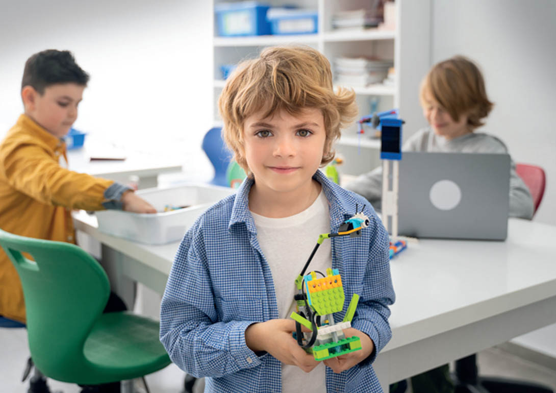Ein Kind hält seinen eigenen Lego-Roboter.