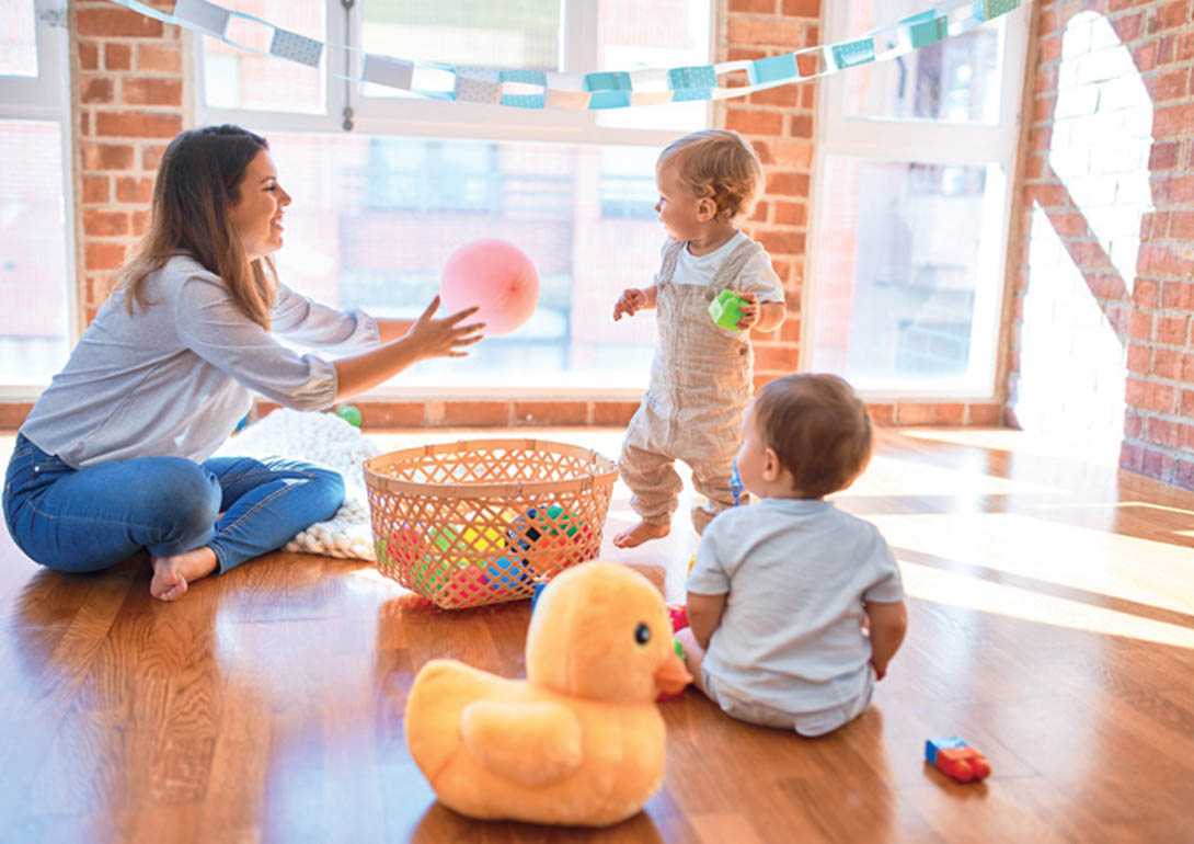 Eine Erwachsene spielt mit zwei Kindern.