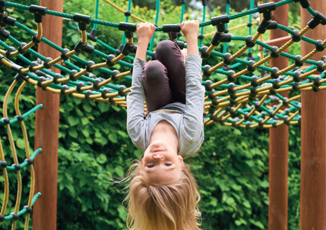 Ein Kind spielt am Klettergerüst.